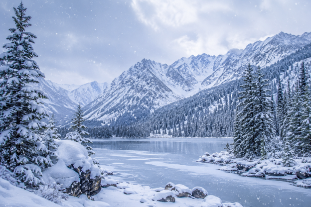 Snow-covered mountains USA, frozen lake, and pine forest